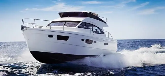 A luxury motor boat planing under throttle finished in a premium topcoat